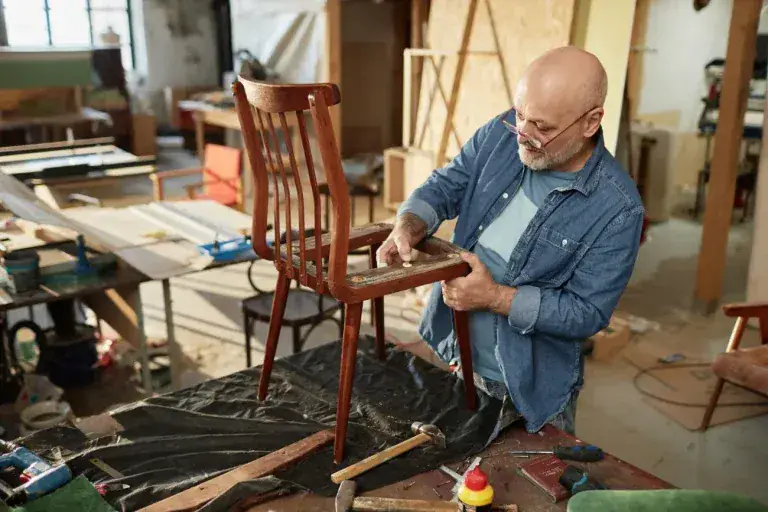 Mains d'artisan tapissier au travail